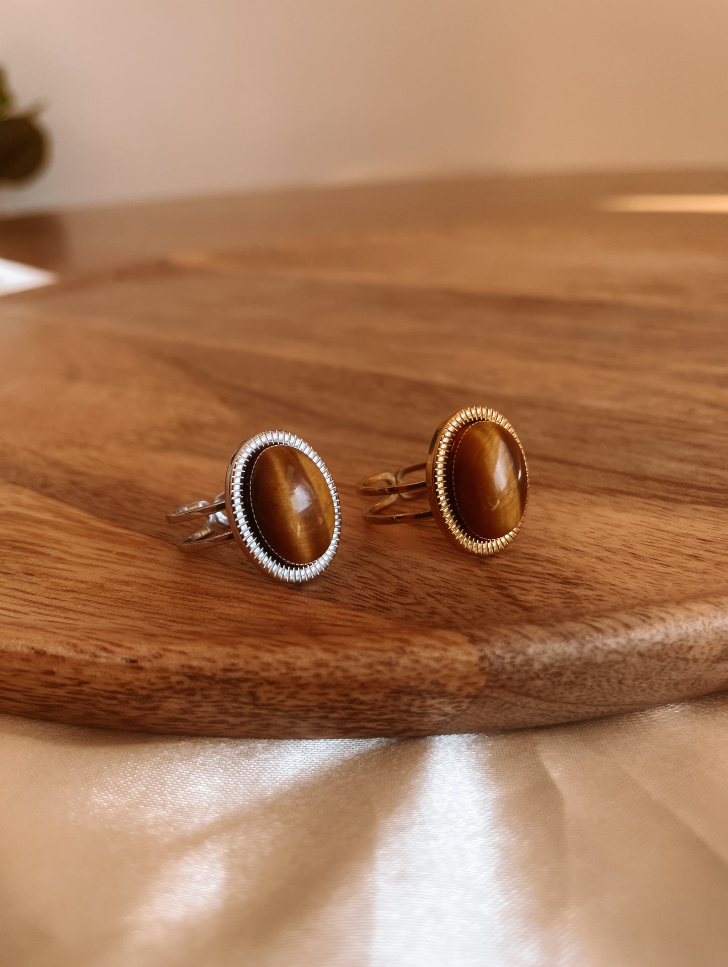 Boho Ringe in Gold und Silber mit ovalem braunem Tigerauge-Stein auf Holz Platte