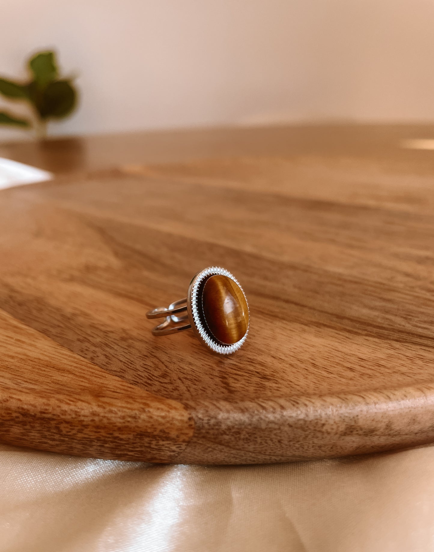 Boho Silberring mit ovalem braunem Tigerauge-Stein an Holzplatte
