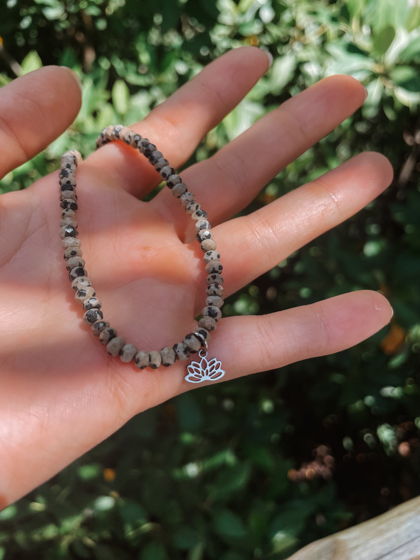 gepunktete Dalmatiner Jaspis-Perlenkette in Silber mit Lotusblüte Anhänger an Hand