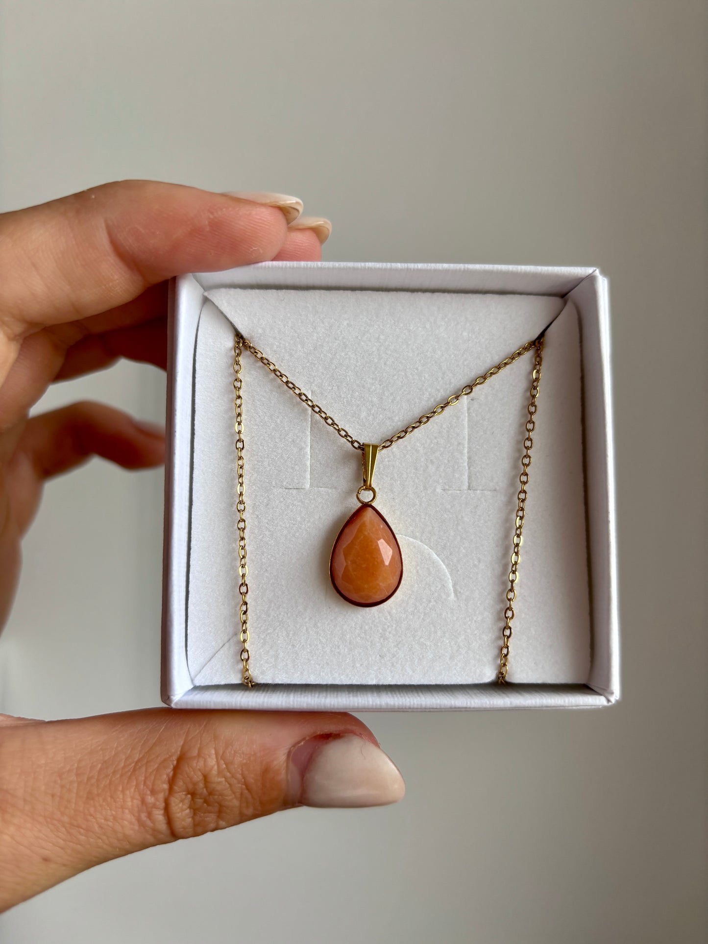 Tropfenförmiger Sonnenstein-Anhänger an feiner Goldkette, in weißer Schmuckbox