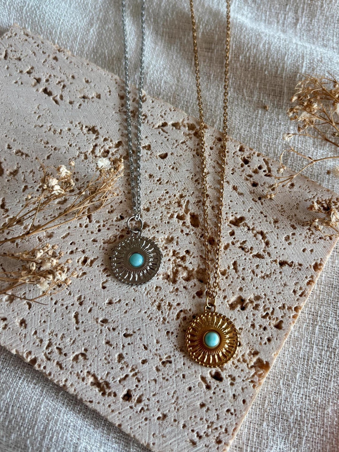 Handgemachte hellblaue Larimar-Ketten mit runden Medaillon Anhänger in Gold und Silber, liegend auf Tablett