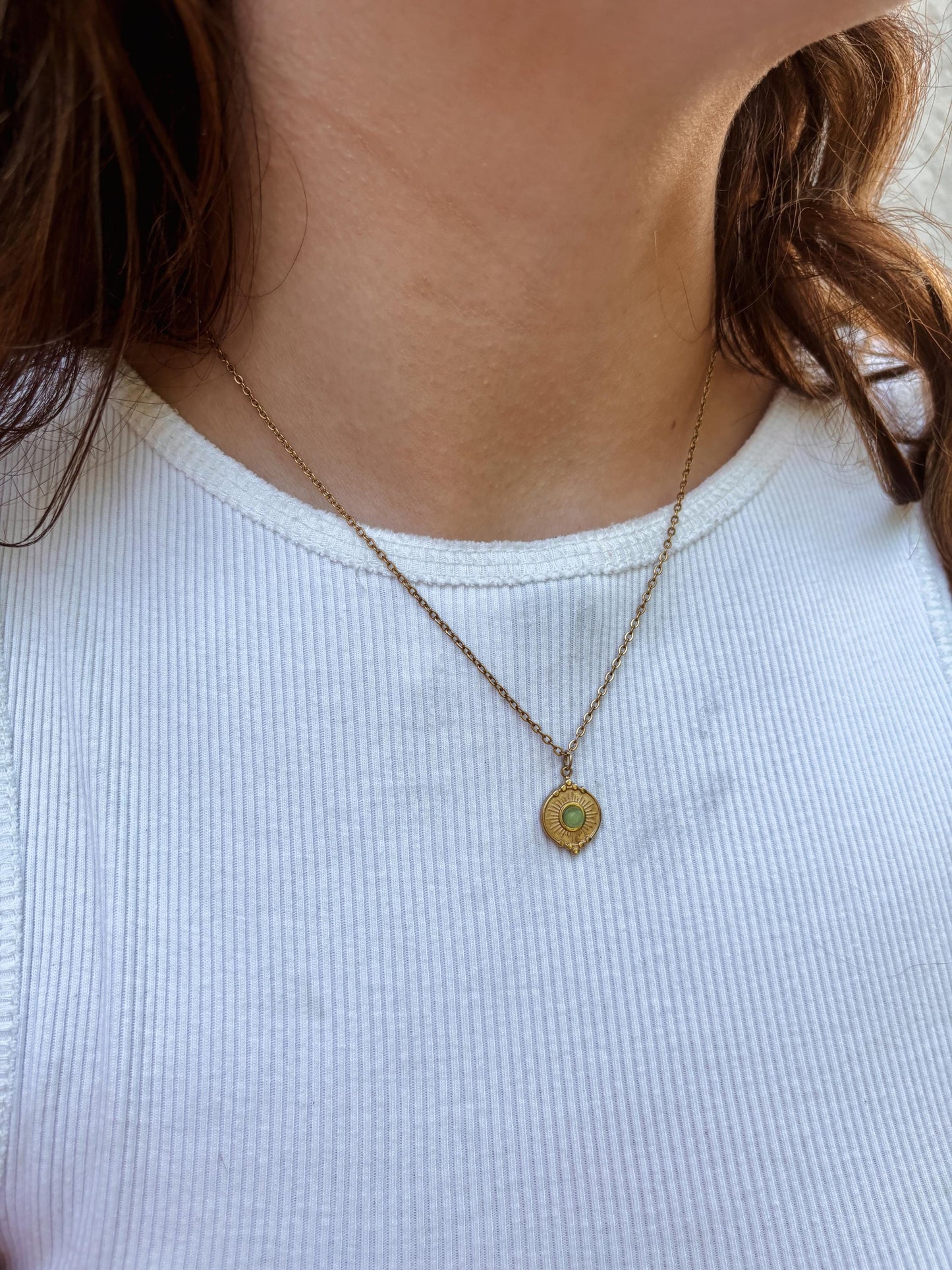 Ovaler grüner Aventurin Stein auf Münze Anhänger an feiner Goldkette, am Dekolleté eines Modells gezeigt