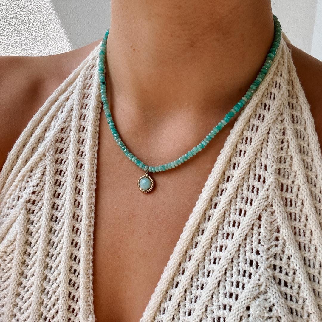 Blaue Amazonit-Perlenkette mit einem runden facettierten Amazonit Anhänger in Gold am Hals eines Modell