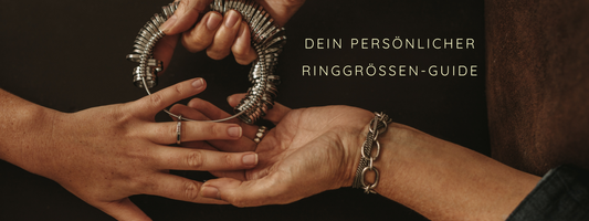 Zwei Hände halten Ringgrößen-Messringe. Der Text "Dein persönlicher Ringgrößen-Guide" ist daneben platziert.