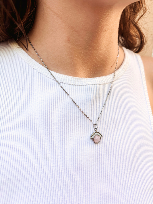 Kette mit silbernem verziertem Anhänger mit facettiertem Rosenquarz Stein am Hals eines Models