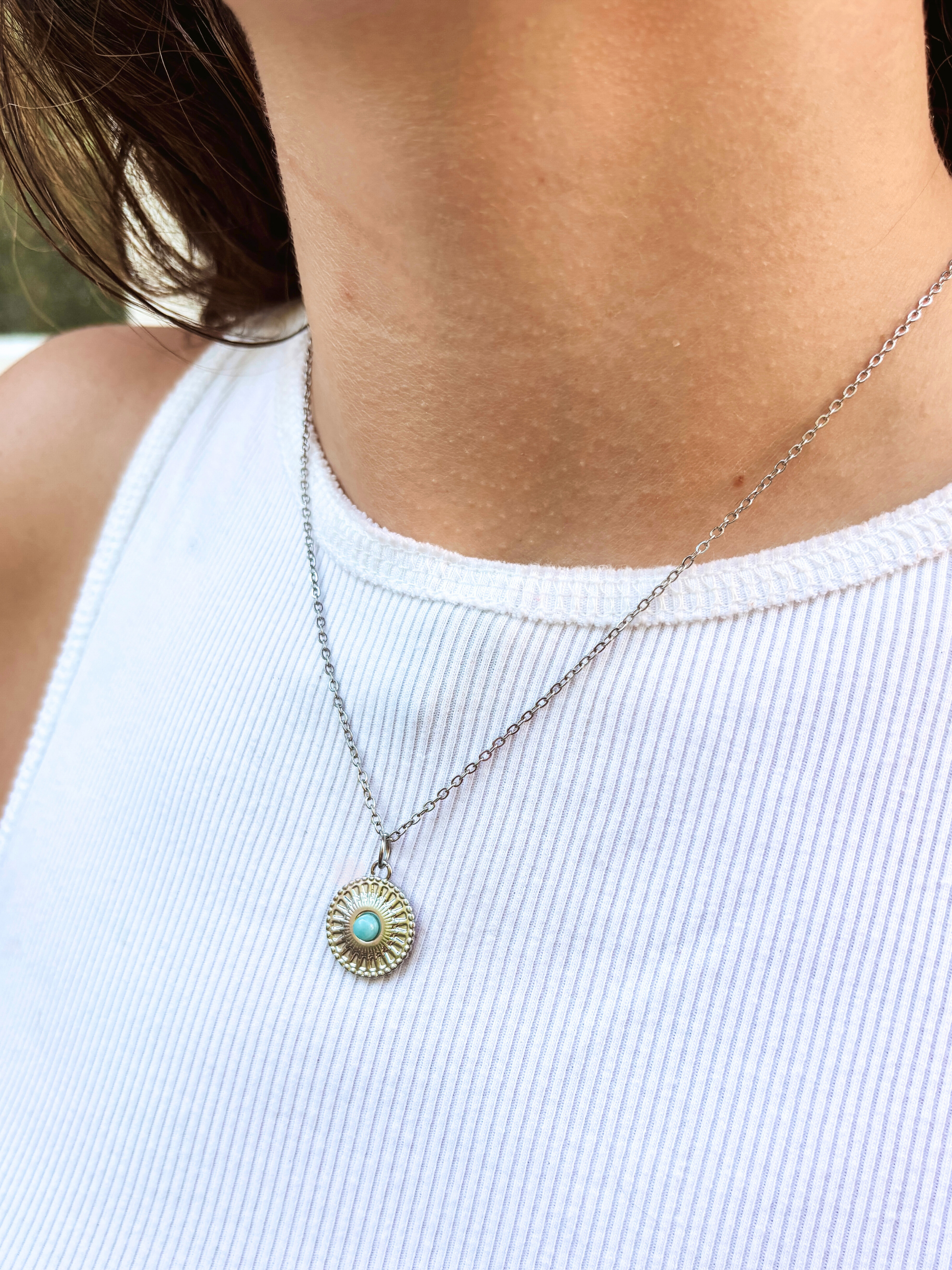 Kette mit silbernem verziertem Medaillon Anhänger mit hellblauem Larimar Stein am Hals eines Models