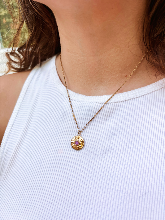 Kette mit goldenem Medaillon Anhänger mit lila Amethyst Stein am Hals eines Models
