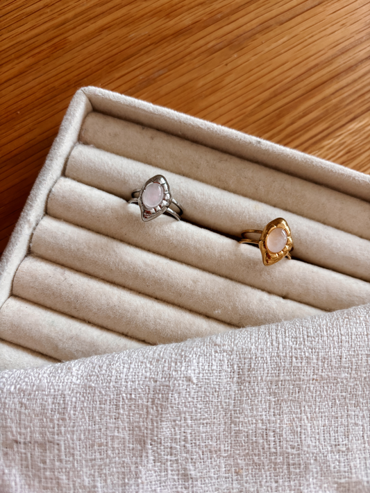 Asymmetrische Statement Ringe in Gold und Silber mit ovalem Rosenquarz-Stein en auf Ring Tablett
