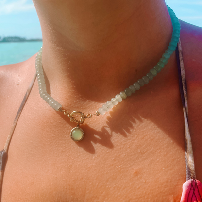 Grüne Aventurin-Perlenkette mit goldenem Aventurin Anhänger am Hals eines Models