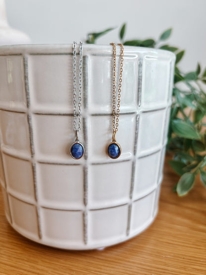 Handgemachte blaue Lapis-Lazuli-Ketten mit ovalem Anhänger in Gold und Silber, hängend an einer Vase