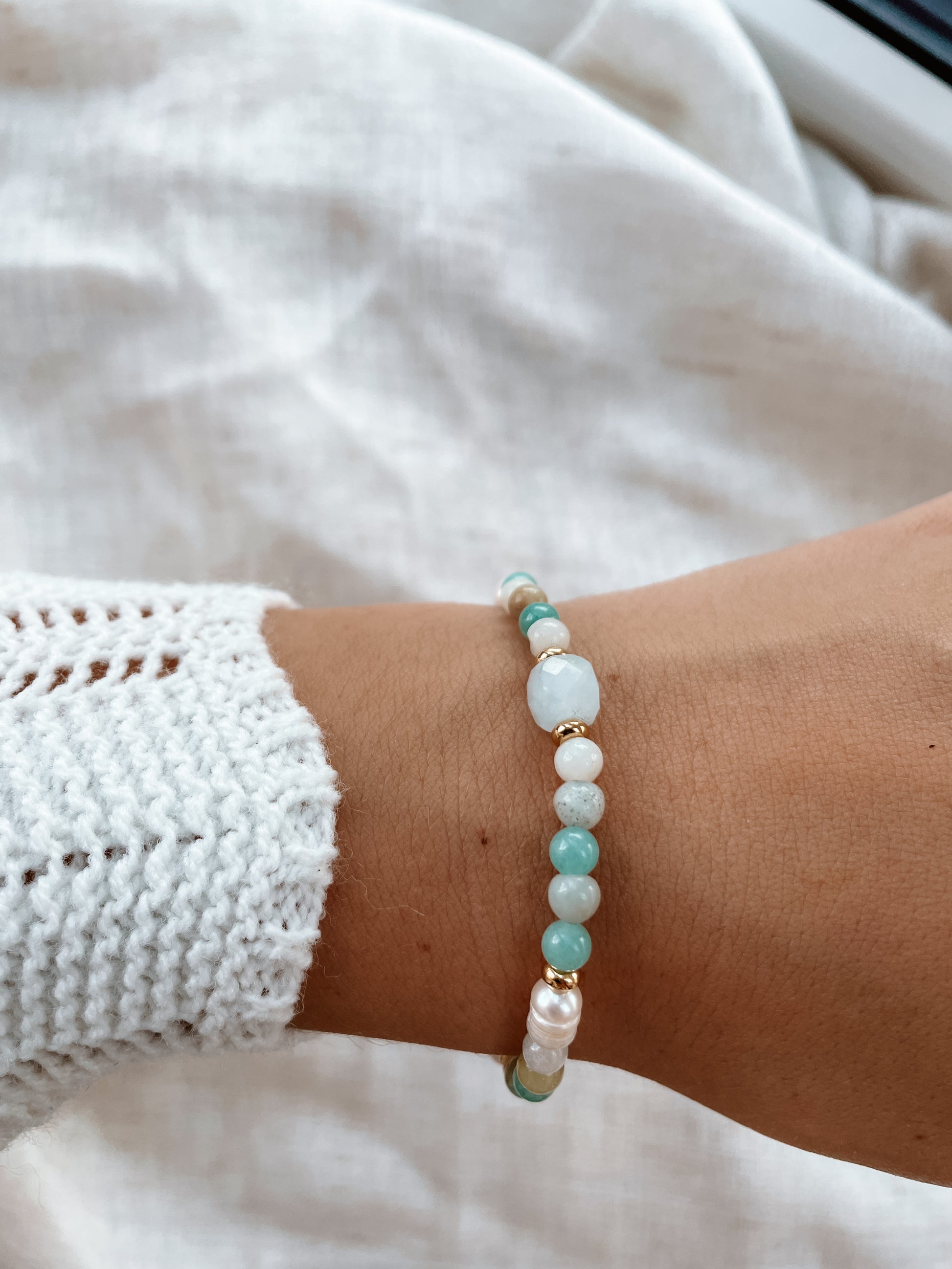 Blaues Amazonit-Perlenarmband in Gold mit Aquamarin Stein an Hand, Detailaufnahme