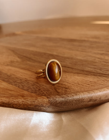 Boho Goldring mit ovalem braunem Tigerauge-Stein an Holz Platte