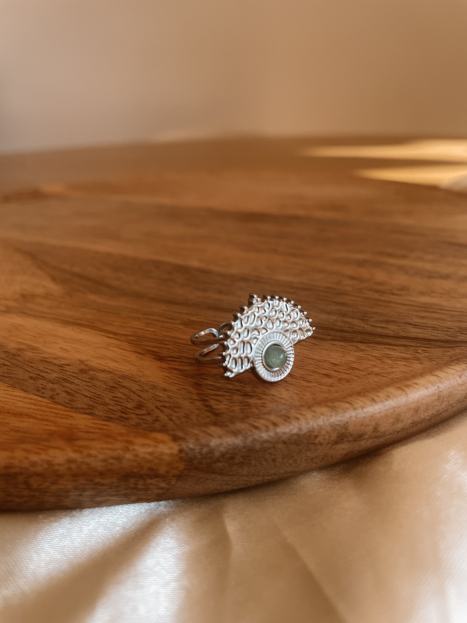 Boho Silberring mit rundem grünen Aventurin-Stein auf Holz Platte
