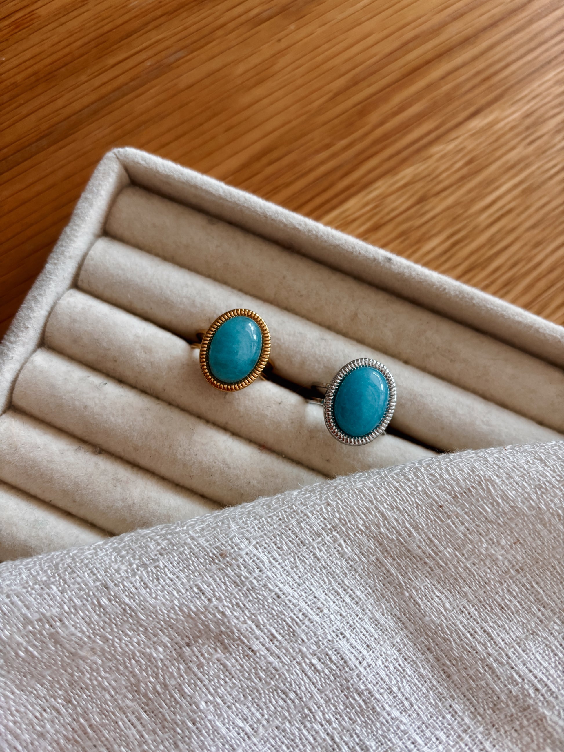 Boho Ringe in Gold und Silber mit ovalen blauen Amazonit-Steinen auf beigem Ring Halter