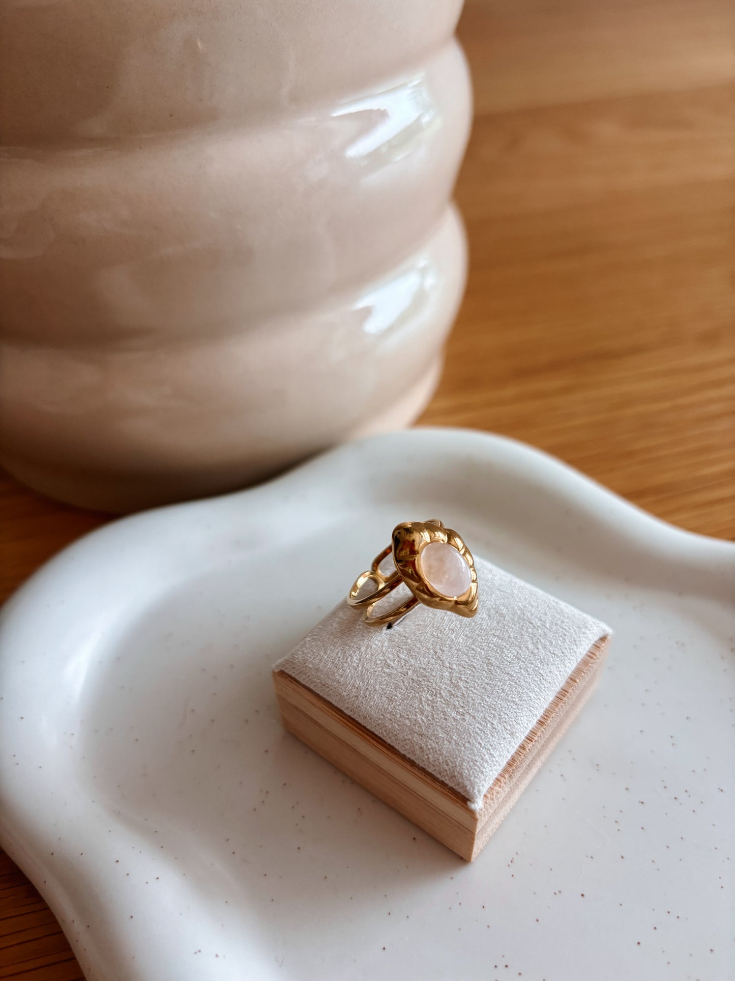 Asymmetrischer Goldring mit ovalem Rosenquarz-Stein auf Ringhalterung
