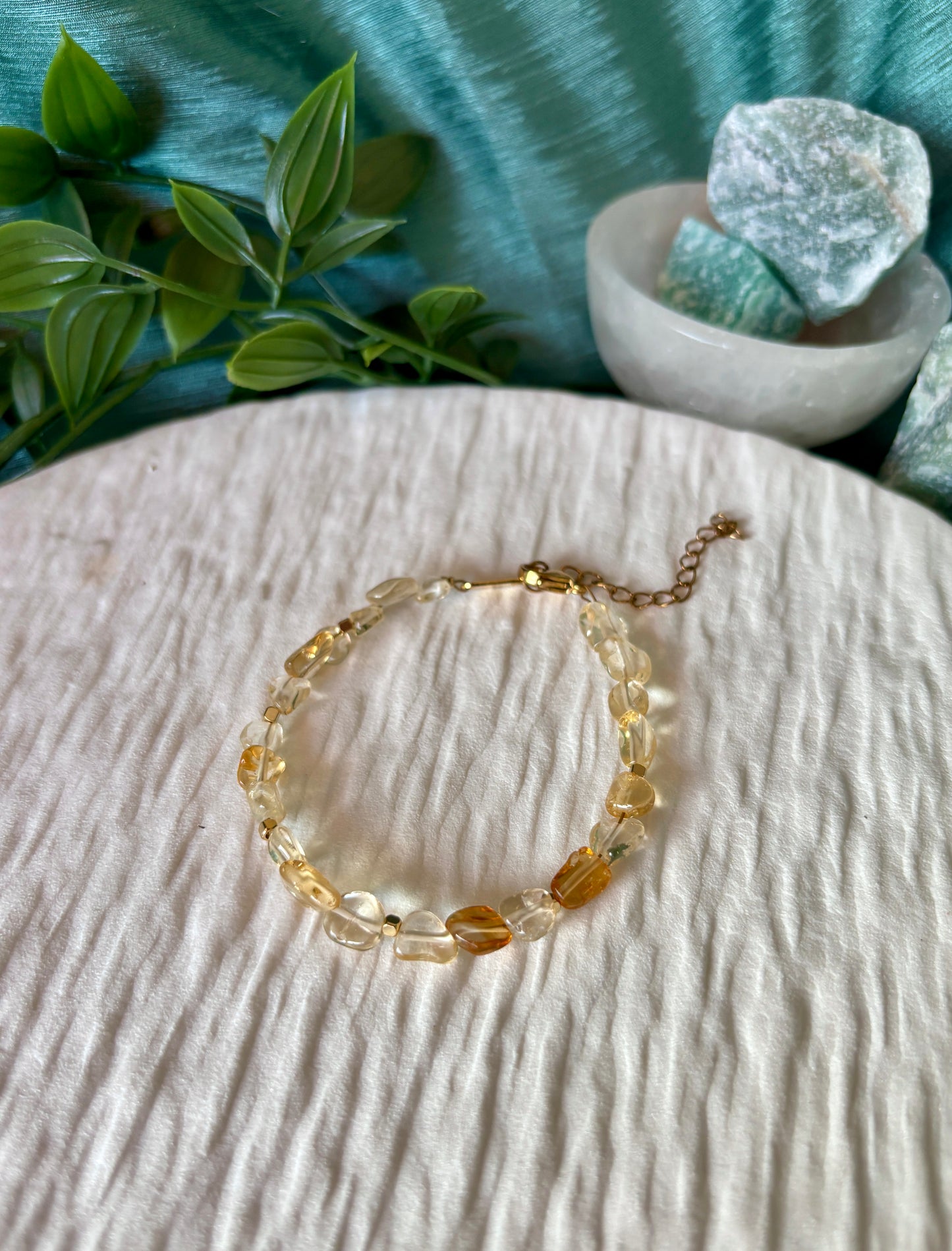 Goldenes Citrin Perlenarmband mit gelben Natursteinen liegend auf weißem Tablett, Ansicht von oben