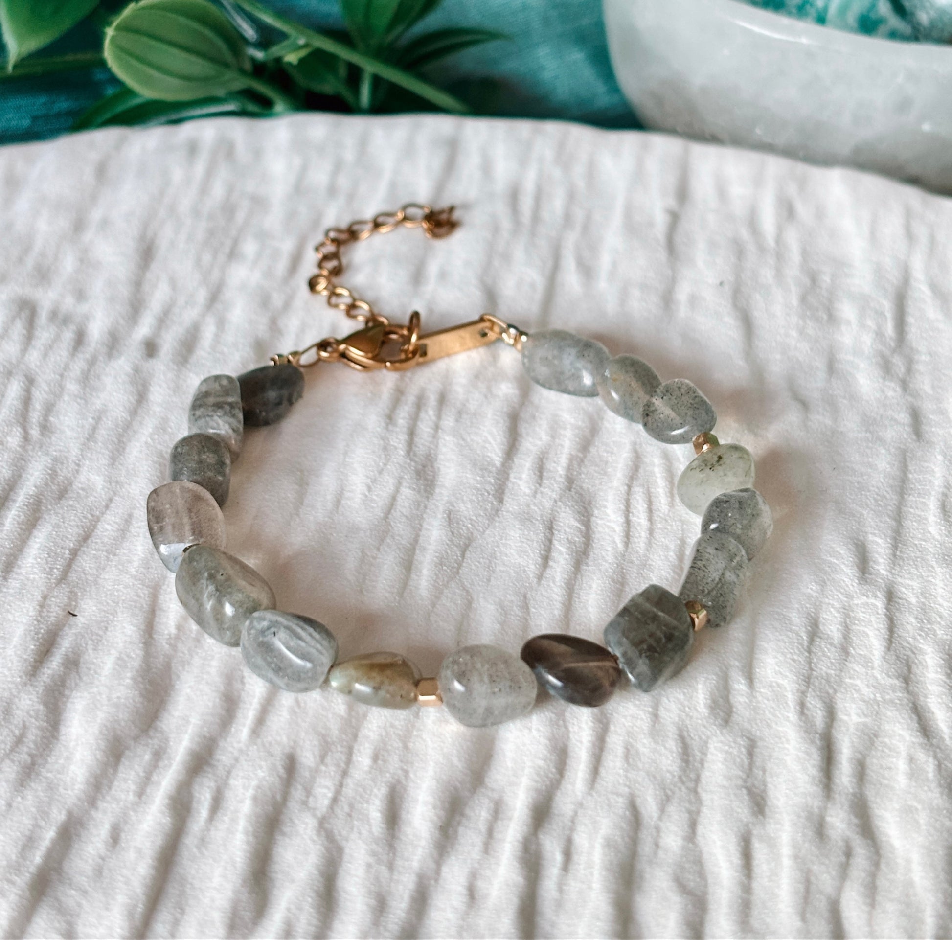 graues Labradorit-Perlenarmband in Gold liegend auf weißem Tablett, Detailaufnahme
