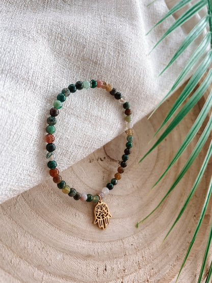 Buntes Turmalin-Perlenarmband mit goldenem Hand von Fatima Anhänger Anhänger liegend auf Tuch