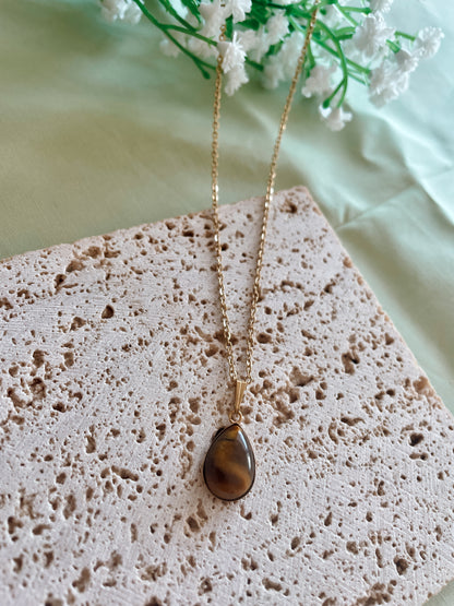 Handgemachte braune Tigerauge-Kette mit Tropfen Anhänger in Gold,  liegend auf Tablett