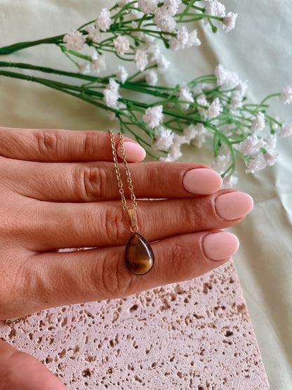 Handgemachte braune Tigerauge-Kette mit Tropfen Anhänger in Gold,  liegend auf Hand
