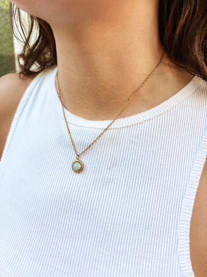 Kette mit goldenem verziertem Anhänger mit türkisem Amazonit Stein am Hals eines Models