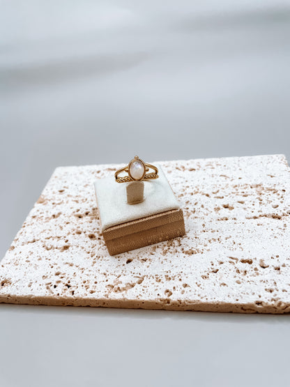 Goldring mit ovalem weißen Mondstein auf Stein Platte