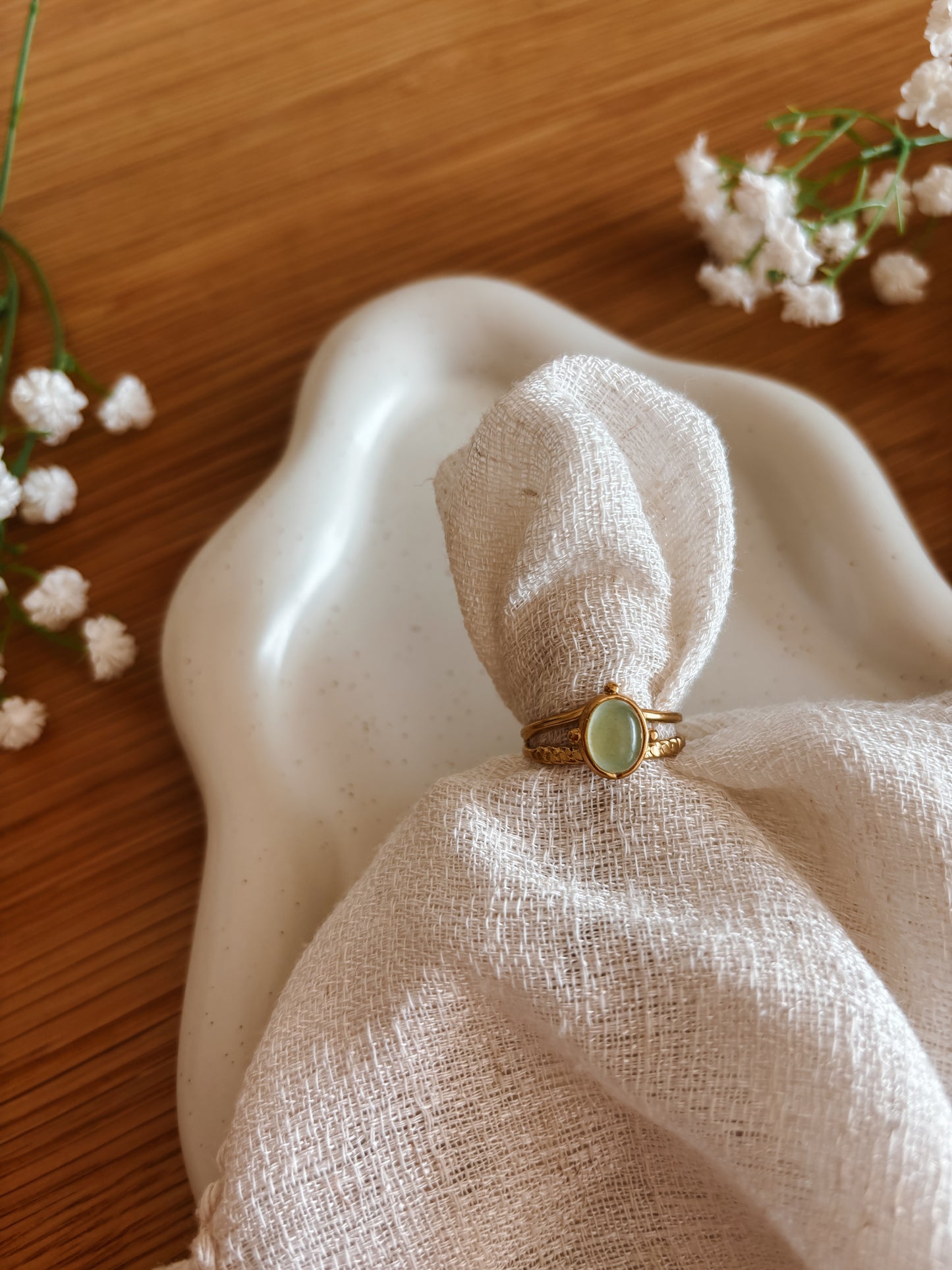 Goldring mit ovalem grünen Aventurin-Stein auf weißem Tuch																								