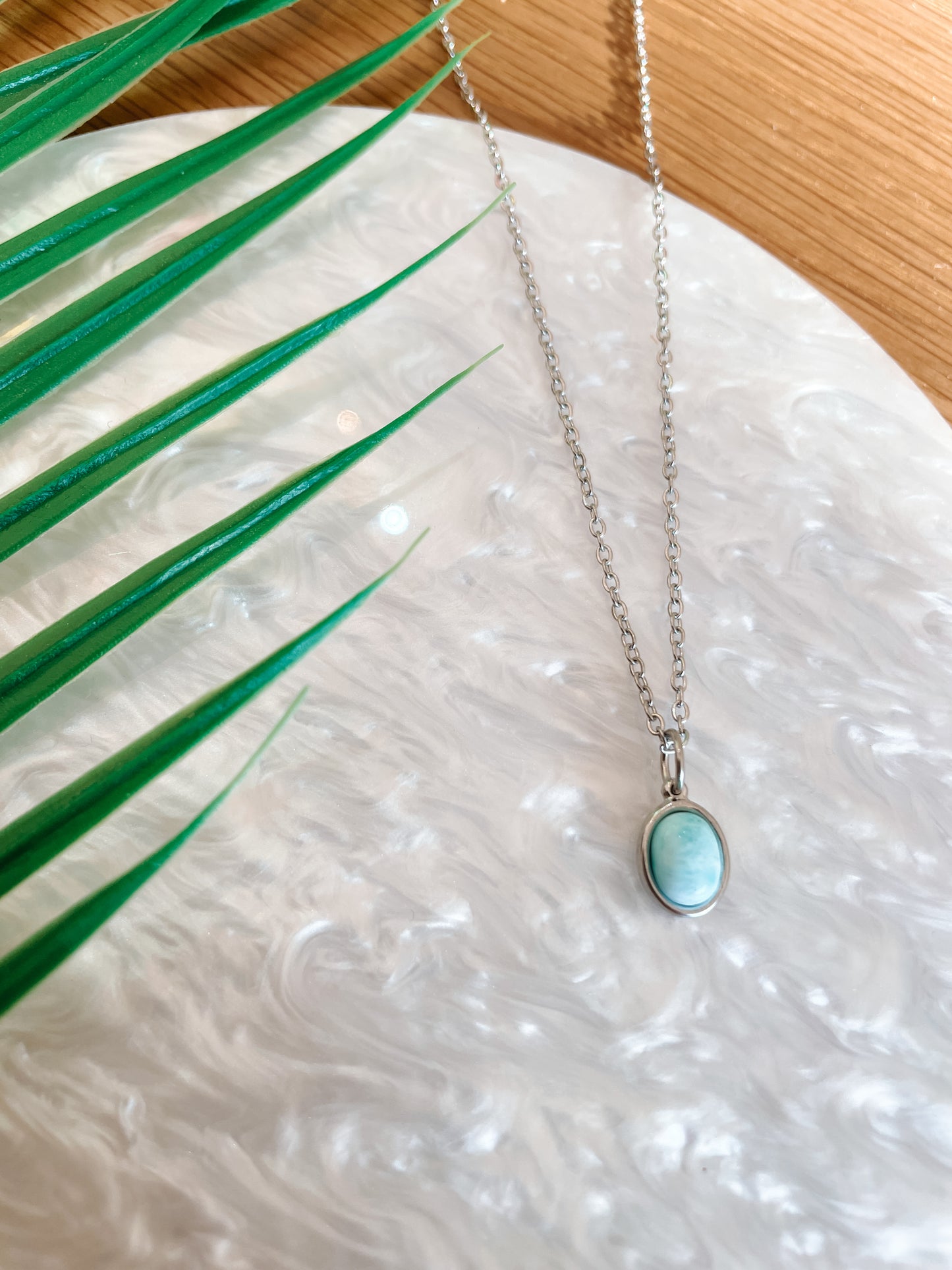 Handgemachte hellblaue Larimar-Kette mit ovalem Anhänger in Silber,  liegend auf Tablett