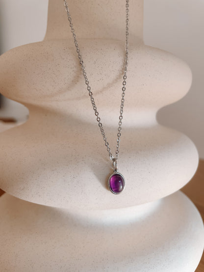 Handgemachte lila Amethyst-Kette mit ovalem Anhänger in Silber, hängend an einer Vase