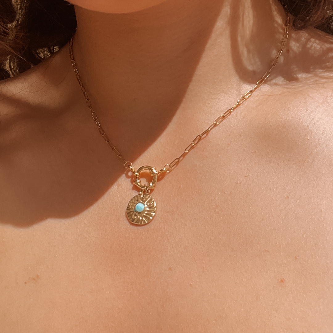 Handgemachte hellblaue Larimar-Kette mit rundem Medaillon Anhänger in Gold,  am Hals eines Models