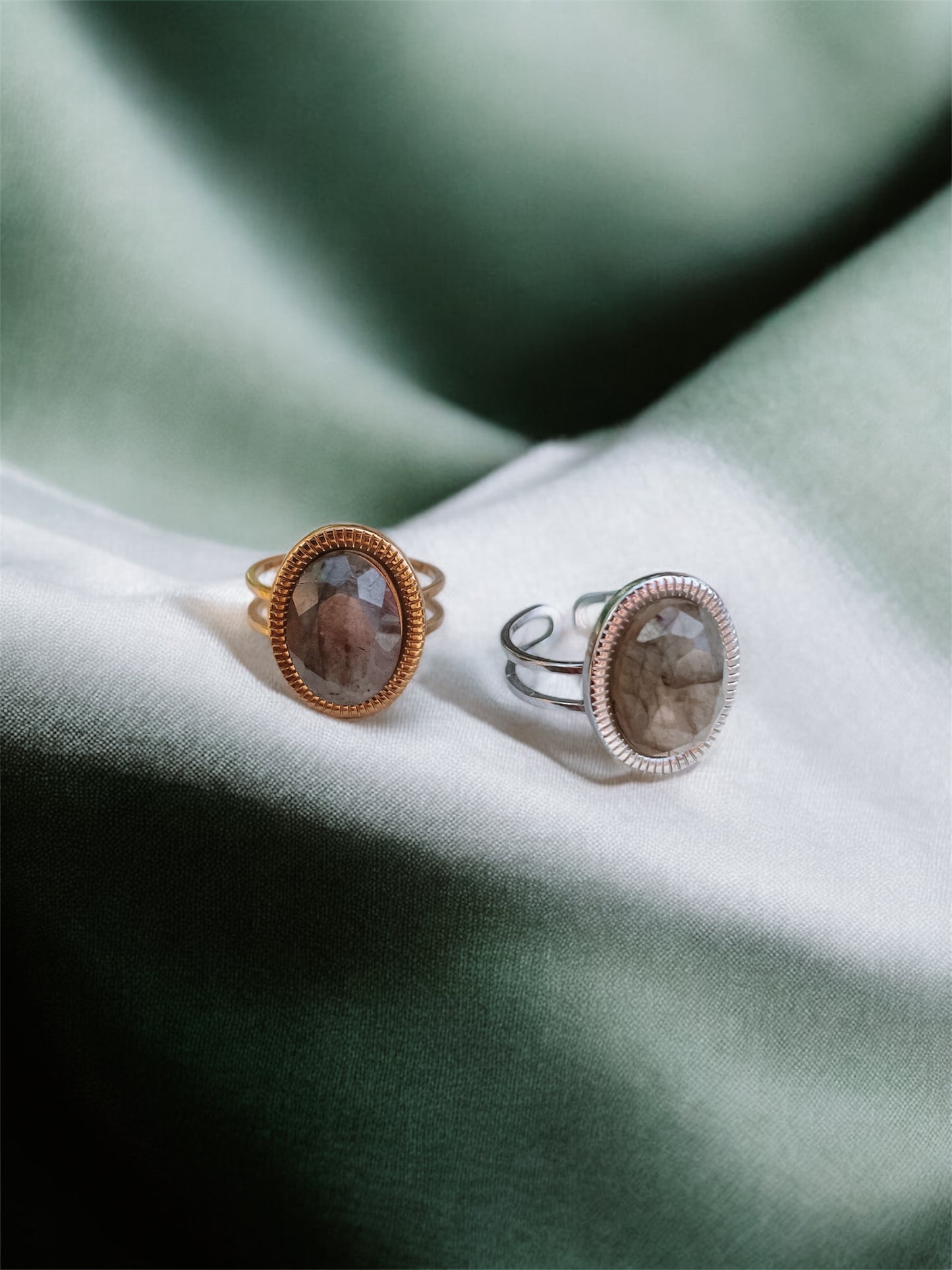 Ringe in Gold und Silber mit ovalem grün-grauen Labradorit-Steinen auf grünem Tuch