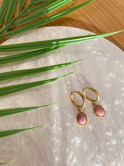 Goldene Creolen-Ohrringe mit ovalen, rosa Rhodonit-Steinen auf Tablett