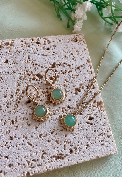 Goldenes Schmuckset mit Ohrring und Halskette mit grünen Aventurin Anhängern liegend auf Stein