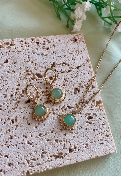 Goldenes Schmuckset mit Ohrring und Halskette mit grünen Aventurin Anhängern liegend auf Stein