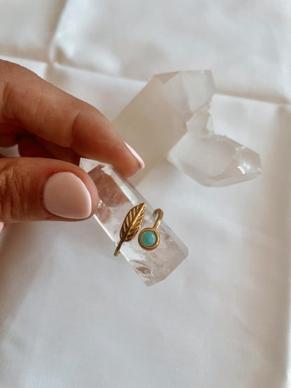 Filigraner Goldring mit rundem hellblauem Larimar-Stein und floralem Blatt Design auf Bergkristall Obelisk