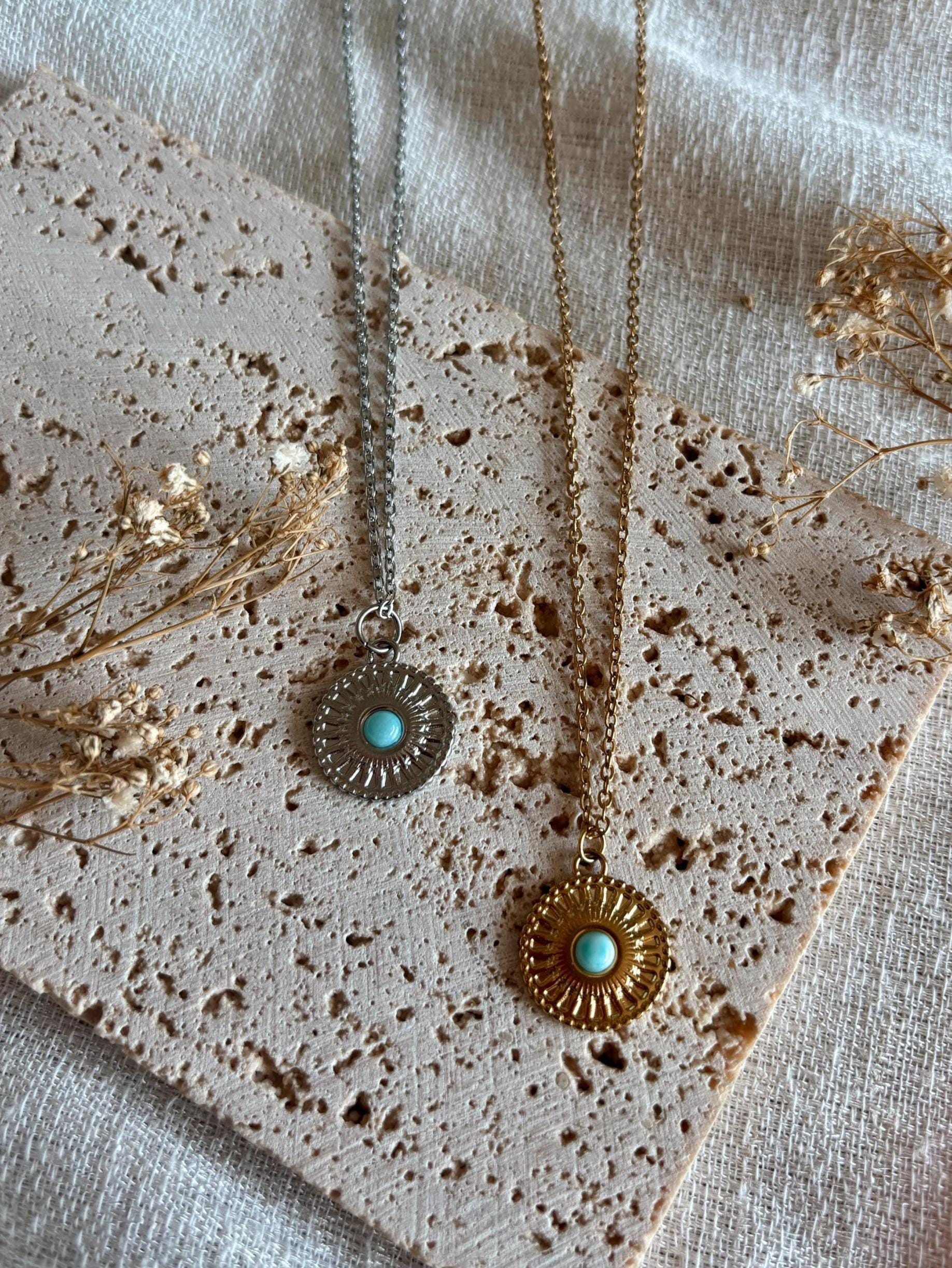 Handgemachte hellblaue Larimar-Ketten mit runden Medaillon Anhänger in Gold und Silber, liegend auf Tablett