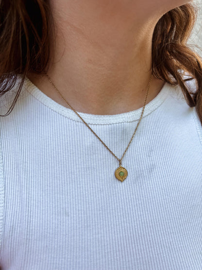 Ovaler grüner Aventurin Stein auf Münze Anhänger an feiner Goldkette, am Dekolleté eines Modells gezeigt