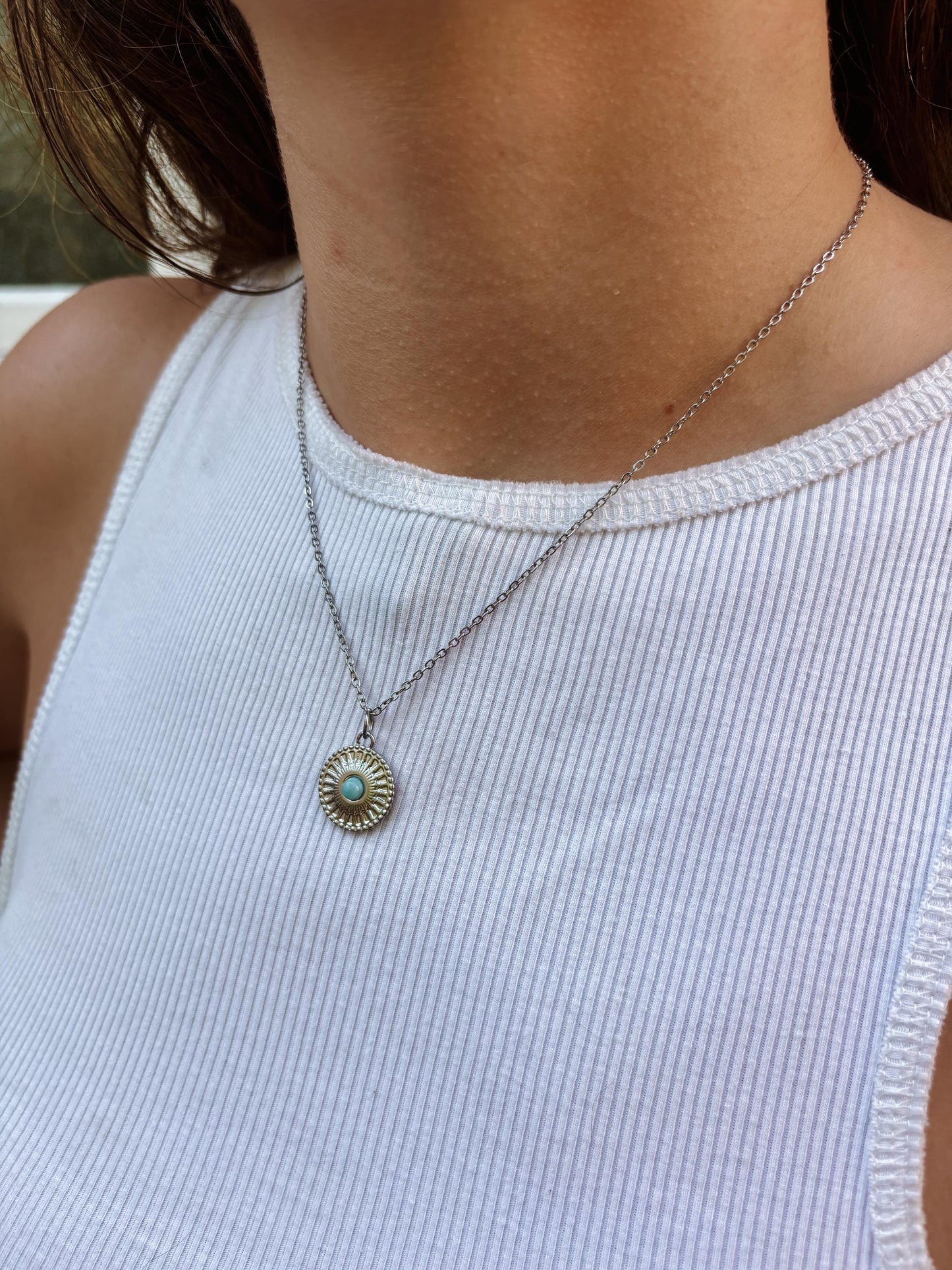 Ovaler hellhellblauer Larimar-Anhänger an feiner Medaillon Silberkette, am Dekolleté eines Modells gezeigt.