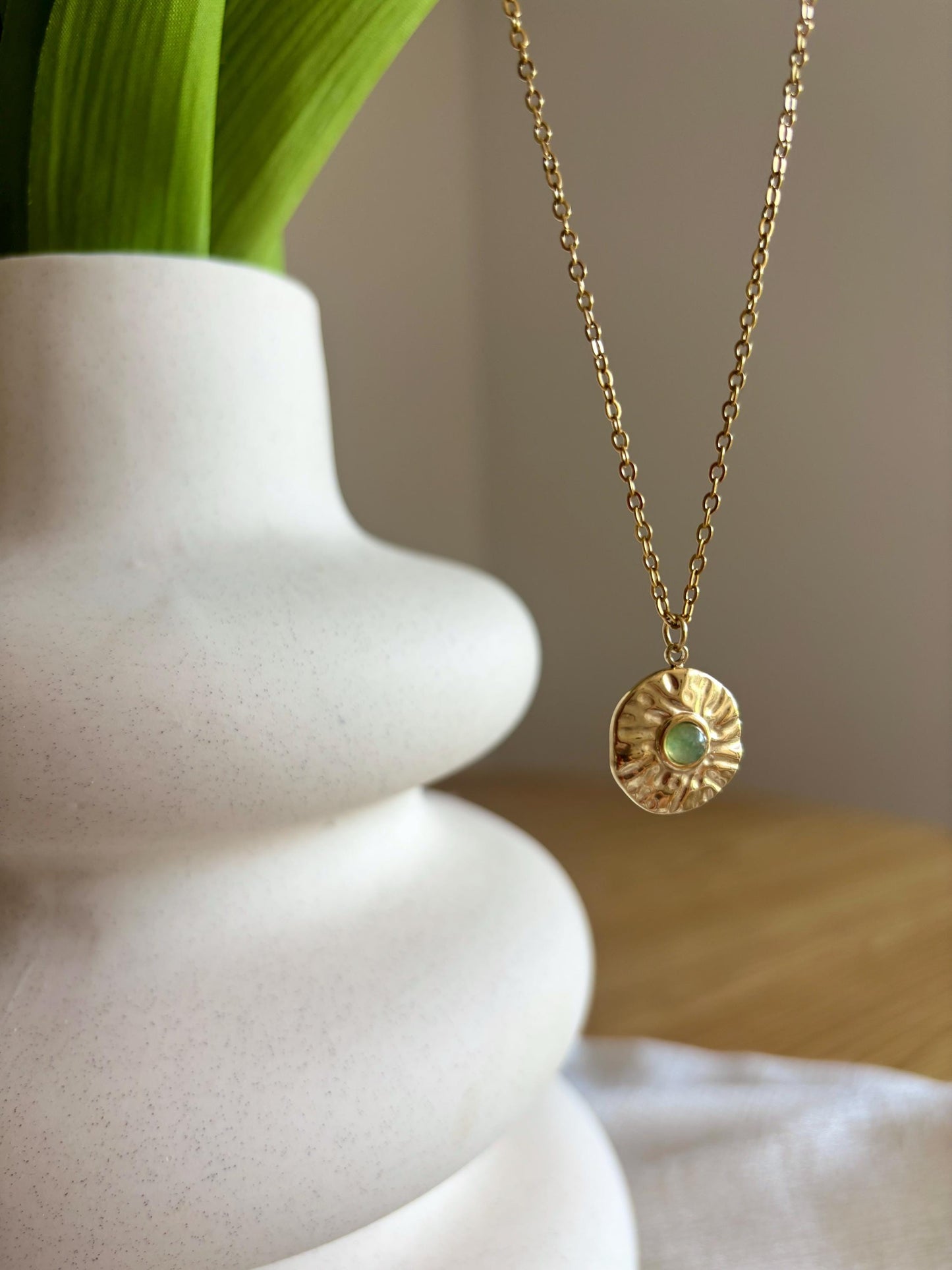 Handgemachte grüne Aventuriner Anhänger an Medaillon Kette in Gold, hängend an einer Vase