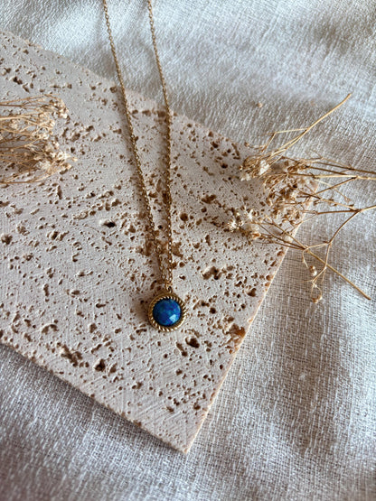 Handgemachte blaue Lapislazuli-Kette mit rundem Anhänger in Gold,  liegend auf Tablett