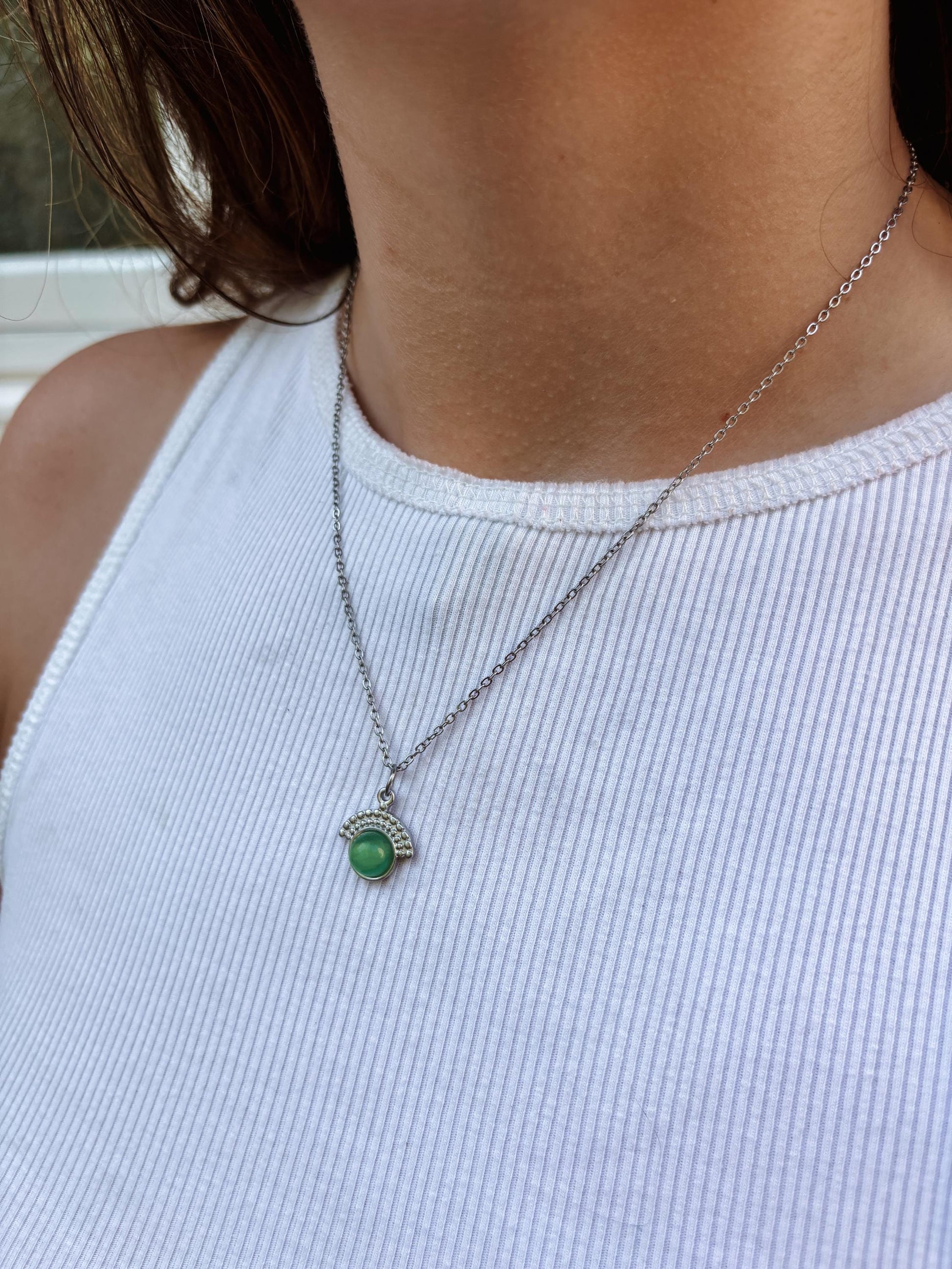 Handgemachte grüne Aventurin-Kette mit rundem Anhänger in Silber, am Hals eines Modells