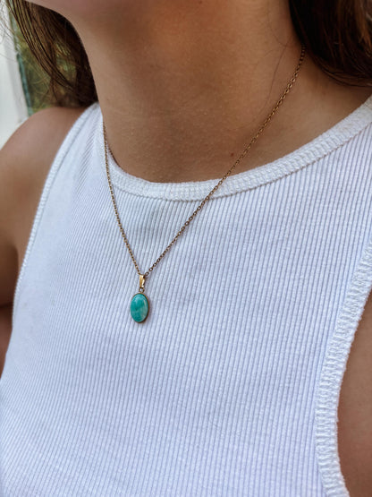 Ovaler hellblauer Amazonit-Anhänger an feiner Goldkette, am Hals eines Modells gezeigt.