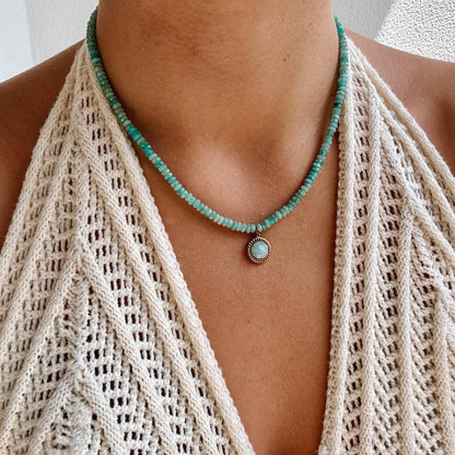 Blaue Amazonit-Perlenkette mit einem goldenen facettierten Amazonit Anhänger am Dekollete eines Modells mit Häkeltop