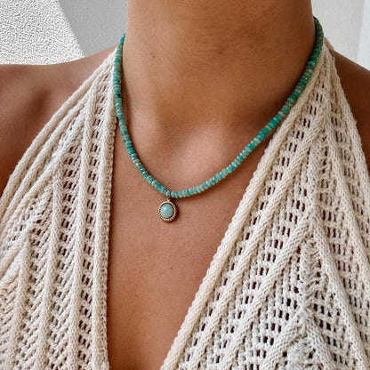 Blaue Amazonit-Perlenkette mit einem runden facettierten Amazonit Anhänger in Gold am Hals eines Modell