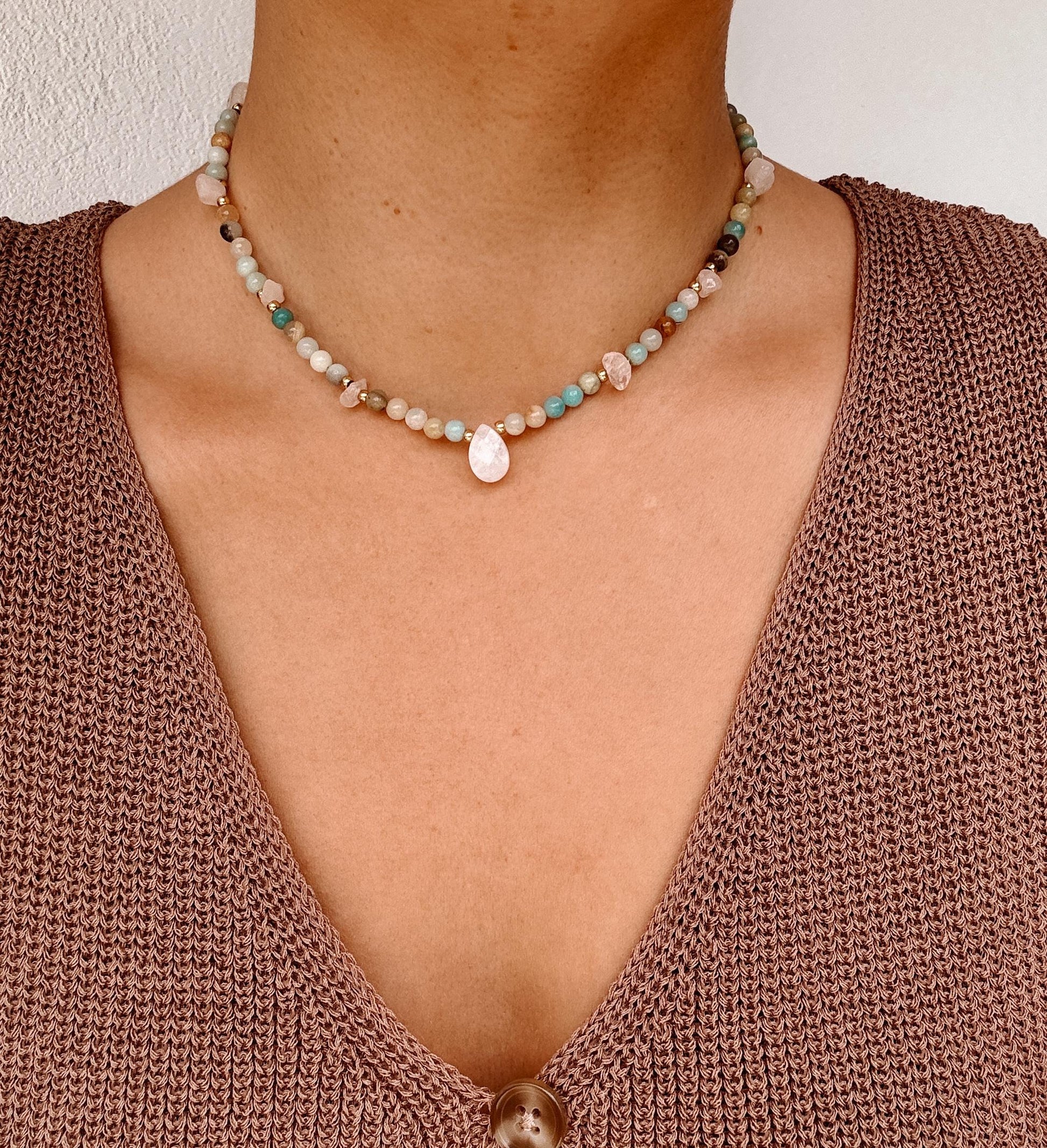 Blaue Amazonit-Perlenkette mit einem weißen facettierten Mondstein Anhänger am Dekollete eines Modells mit Häkeltop