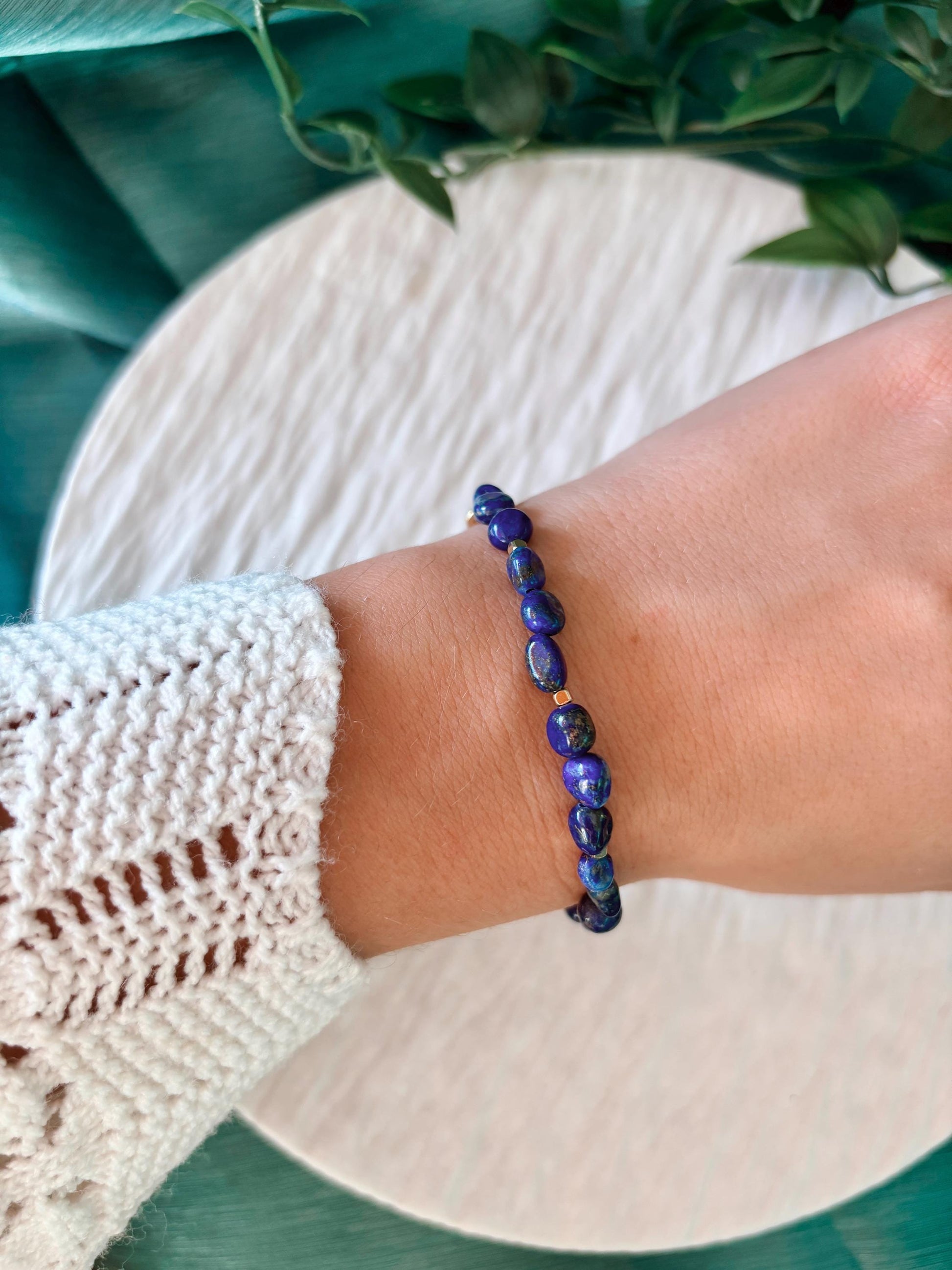 Goldenes Lapislazuli Perlenarmband mit blauen Natursteinen am Handgelenk