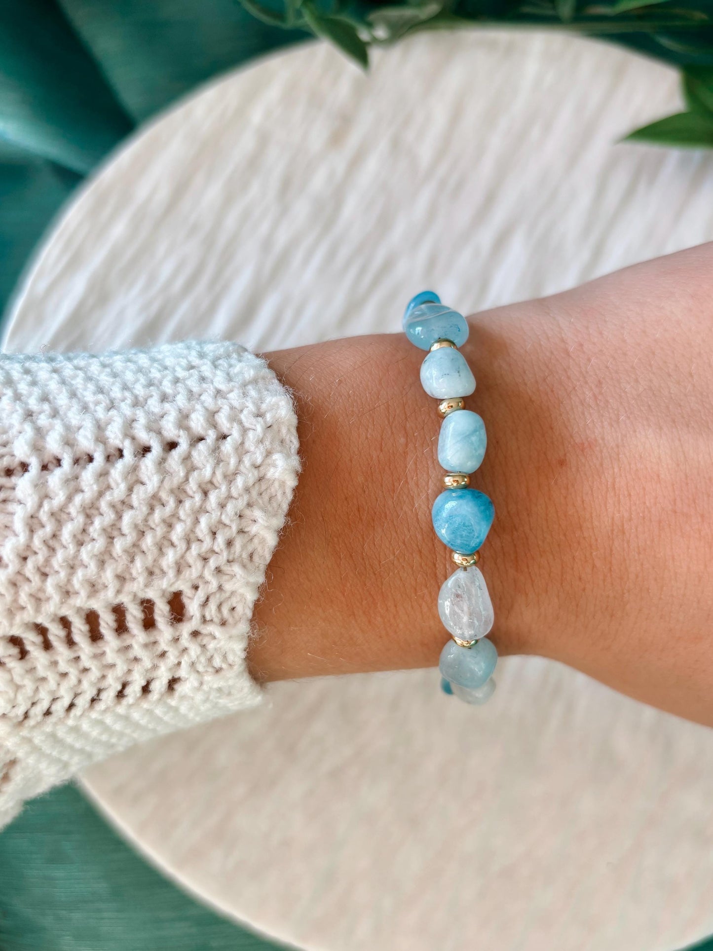 Goldenes Aquamarin Perlenarmband mit blauen Natursteinen am Handgelenk