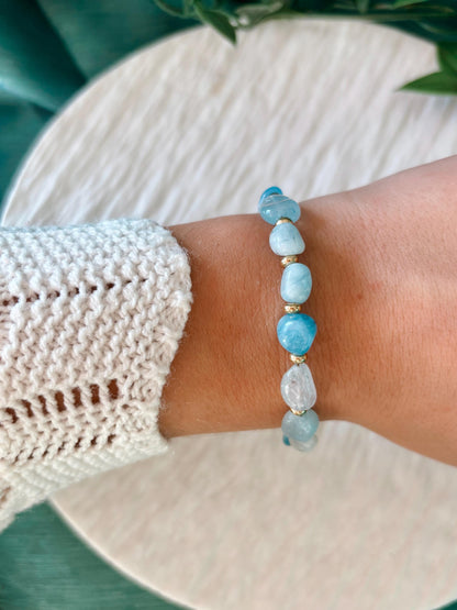 Goldenes Aquamarin Perlenarmband mit blauen Natursteinen am Handgelenk