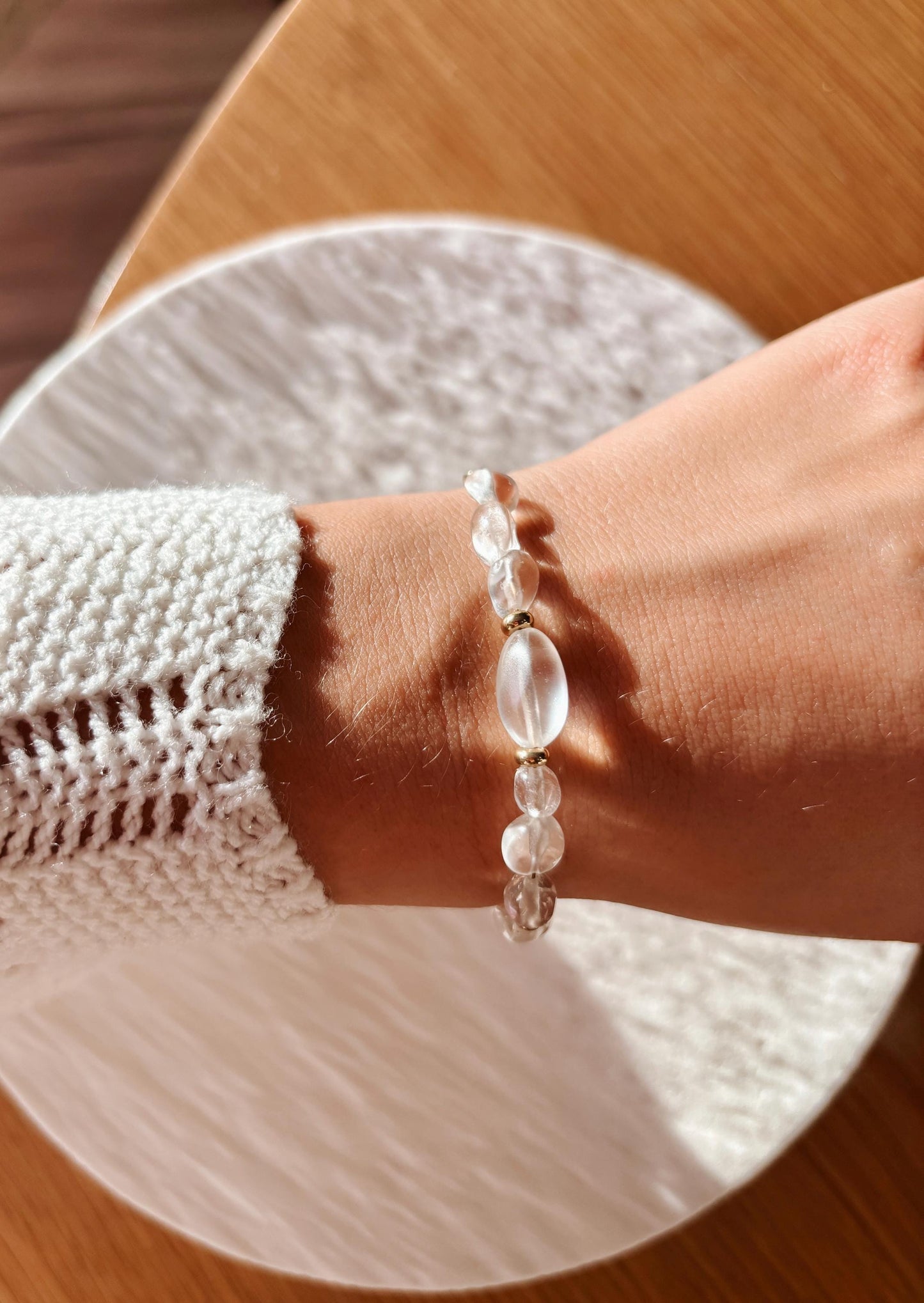 Goldenes Bergkristall Perlenarmband mit weißen Natursteinen am Handgelenk