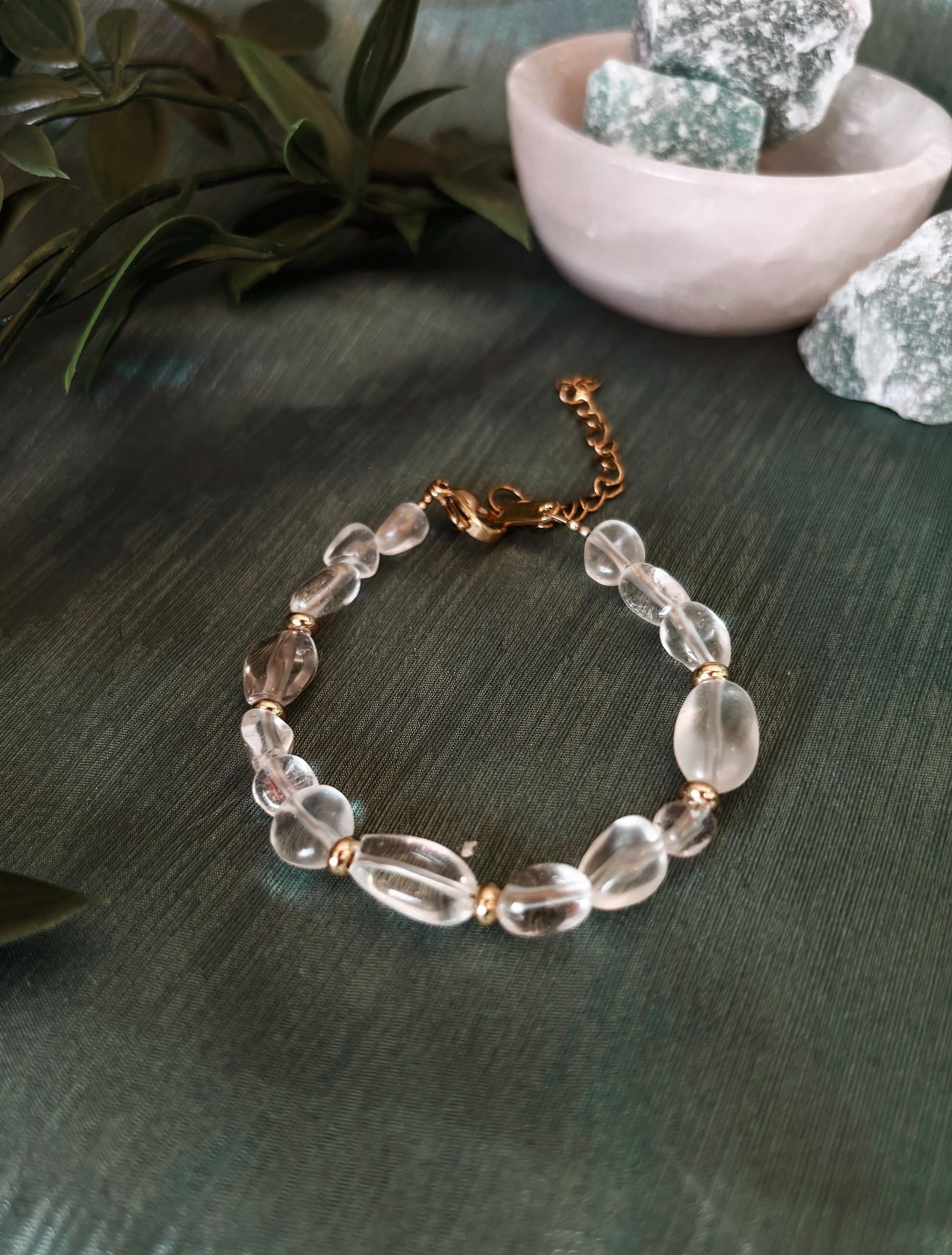 Goldenes Bergkristall Perlenarmband mit weißen Natursteinen liegend auf grünem Tuch, Ansicht von oben